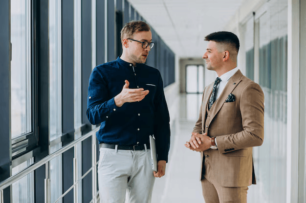 two-male-colleagues-office-standing-with-laptop_1303-19621